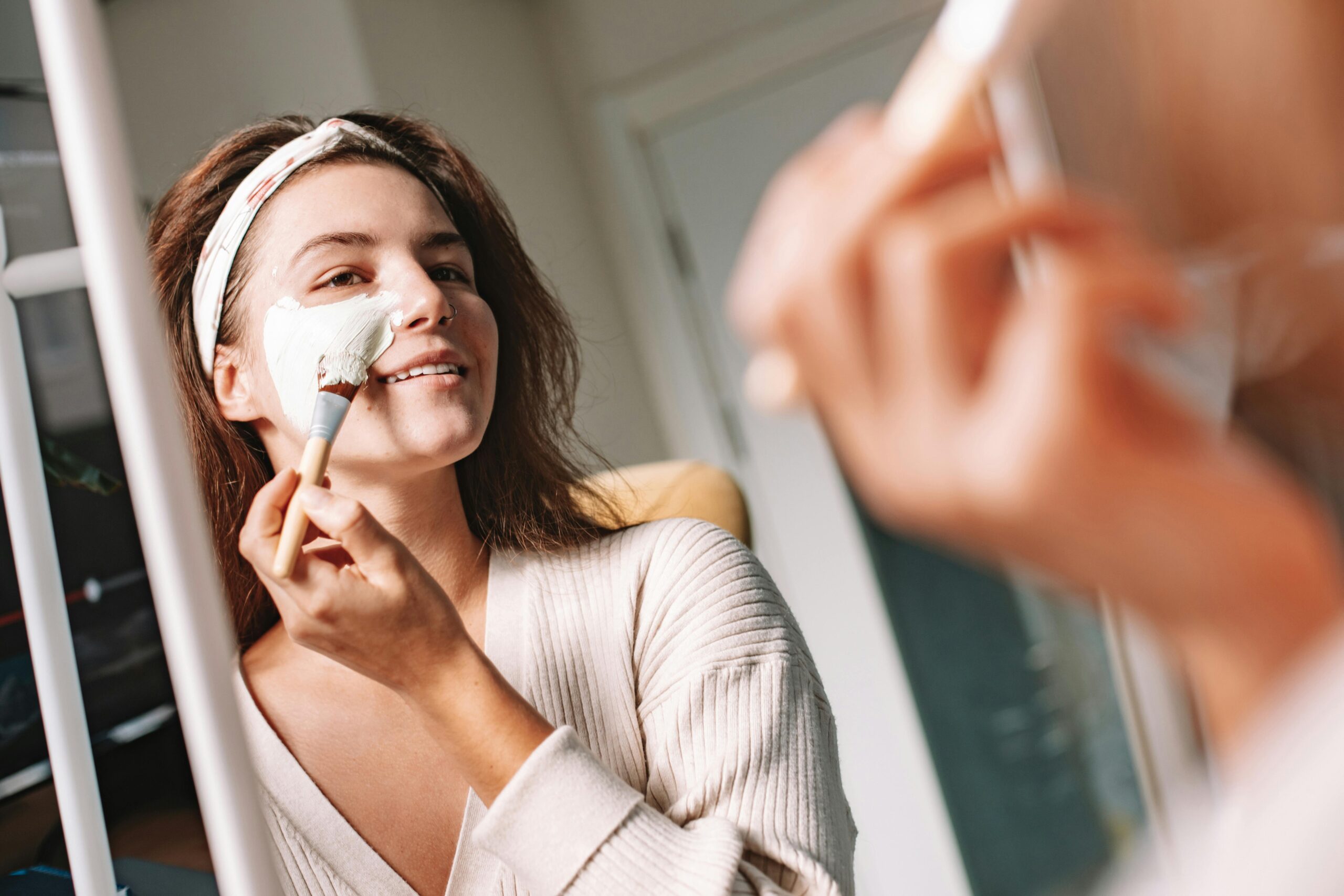 she is applying a face pack on her face with a brush