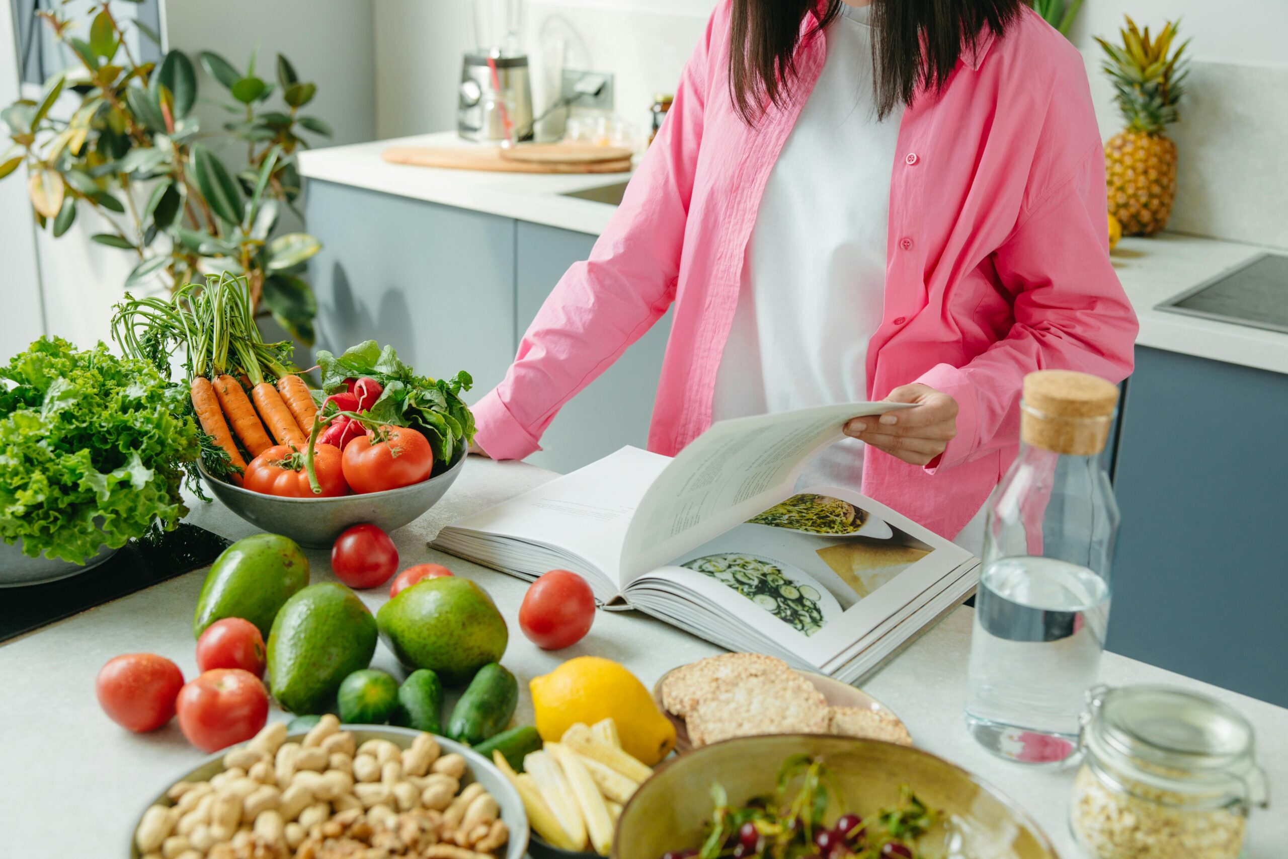 she has a food book, front of her vegetables